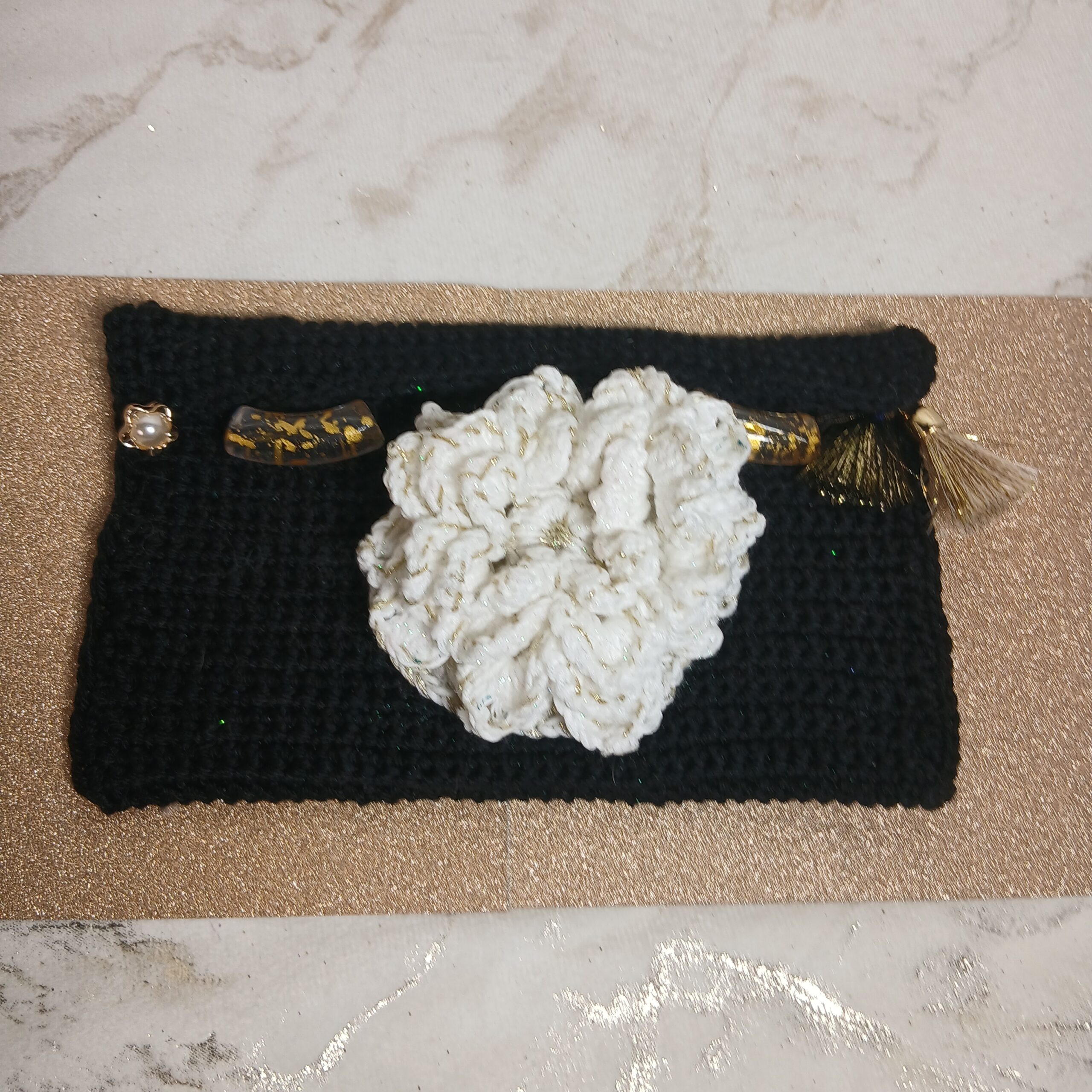 La pochette trousse noire et fleur blanche